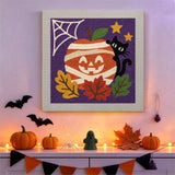 Tableau punch needle citrouille momie accroché au mur parmi des décorations d'Halloween