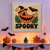 Tableau punch needle citrouille ricanante accroché au mur dans une déco d'Halloween