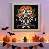 Tableau punch needle bouquet et mains de squelette accroché au mur dans une déco d'Halloween