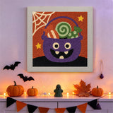 Tableau punch needle seau à bonbons accroché au mur dans une déco d'Halloween