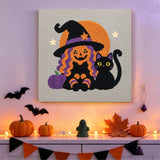 Tableau punch needle sorcière et chat noir accroché au mur parmi des décorations d'Halloween