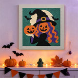 Tableau punch needle sorcière tête de citrouille accroché au mur dans une déco d'Halloween