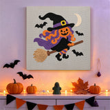 Tableau punch needle sorcière volante accroché au mur dans une déco d'Halloween
