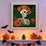 Tableau punch needle squelette couronné de fleurs accroché au mur dans une déco d'Halloween