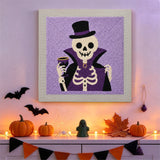 Tableau punch needle squelette comte accroché au mur dans une déco d'Halloween