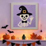 Tableau punch needle squelette coucou accroché au mur dans une déco d'Halloween