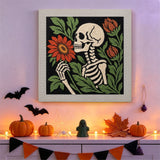 Tableau punch needle squelette à la fleur accroché au mur dans une déco d'Halloween