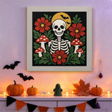 Tableau punch needle squelette fleuri accroché au mur dans une déco d'Halloween