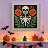Tableau punch needle squelette fleuri accroché au mur dans une déco d'Halloween
