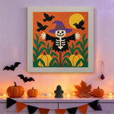 Tableau punch needle squelette épouvantail accroché au mur dans une déco d'Halloween