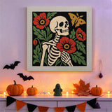 Tableau punch needle squelette aux pavots accroché au mur dans une déco d'Halloween