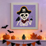 Tableau punch needle squelette pirate accroché au mur dans une déco d'Halloween