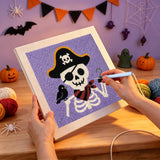 Broderie punch needle en cours, aiguille en main, sur la toile du squelette pirate et de son corbeau