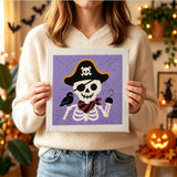 Tableau punch needle squelette pirate tenu en main pour montrer sa taille