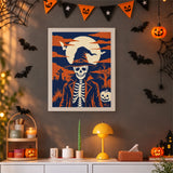 Tableau punch needle squelette au chapeau pointu accroché au mur dans une déco d'Halloween