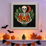 Tableau punch needle squelette et lune rouge au mur dans une déco d'Halloween
