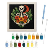 Contenu du kit punch needle squelette aux soucis : toile sur cadre, aiguilles et fils de laine