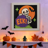 Tableau punch needle squelette et pierre tombale accroché au mur dans une déco d'Halloween