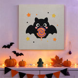 Tableau punch needle chauve-souris à la sucette accroché au mur dans une déco d'Halloween