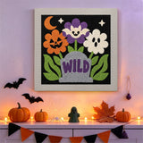 Tableau punch needle tombe fleurie au mur d'une pièce décorée pour Halloween