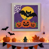 Tableau punch needle trio de citrouilles accroché au mur dans une déco d'Halloween