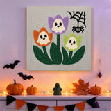 Tableau punch needle tulipes fantômes accroché au mur dans une déco d'Halloween