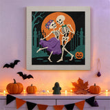 Tableau punch needle couple de squelettes accroché au mur dans une déco d'Halloween