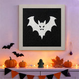 Tableau punch needle chauve-souris blanche sur fond noir accroché au mur dans une déco d'Halloween