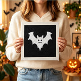 Tableau punch needle chauve-souris vampire tenu en main pour montrer sa taille