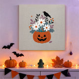 Tableau punch needle vase citrouille fleuri accroché au mur dans une déco d'Halloween